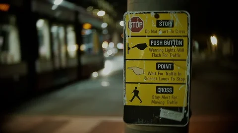 Close up of stoplight button instructions with cars passing by Video stock 104537017