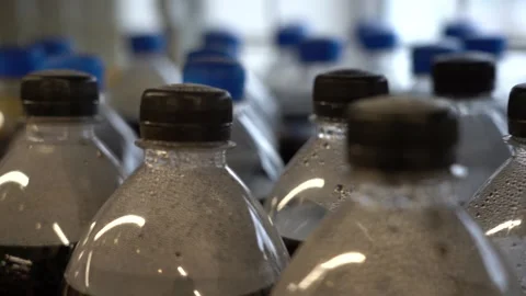 Close-up on a store shelf a row of plastic bottles with different colored soda. Stock Footage 145761052