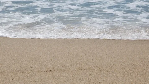 Close up, straight on shot of white waves breaking on sandy beach Stock Footage 104416058