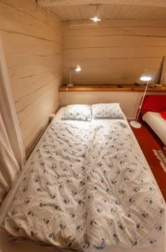 Close, straight-on view of an unmade double bed with floral bedding in a ru.. Stock Photos