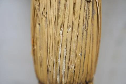 Close-up of a straw broom handle. Straw background. Stock Photos