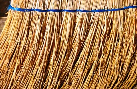 Close up of straw broom in work Stock Photos