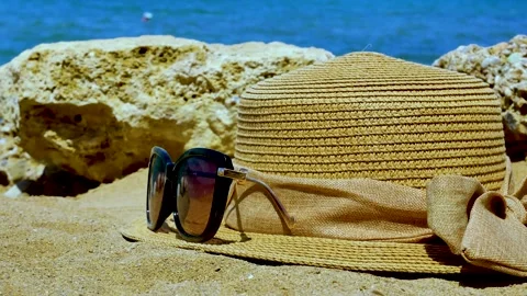 Close-up of straw hat, sunglasses on a sandy beach on a tropical coast Stock Footage 245565083