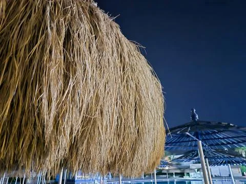 Close Up of Straw Umbrella at Night Photos