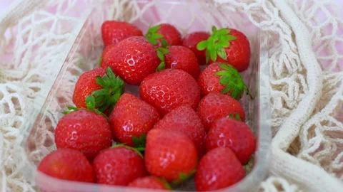 Close-up of strawberries in a white mesh bag bought at an eco farmer's market Stock Footage 211862696