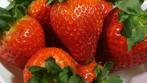 Close up strawberry being picked up from a white bowl of strawberries Stock Footage 104677341