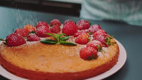 Close-up of strawberry cake dusted with powdered sugar on kitchen counter Stockbeeldmateriaal 342867091