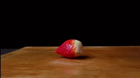 Close up of a strawberry falling down on a cutting board Video stock 153205876