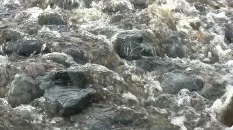 Close up of a stream flowing over stones on a beach Stock-Footage 12337396