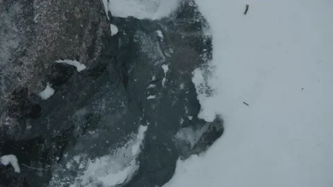 Close-up of a stream of water and bubbles under transparent ice among the snow Stock-Footage 160115755