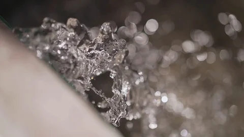 Close-up of a stream of water pouring over. Drops sparkle in the sun Stock Footage 129362766