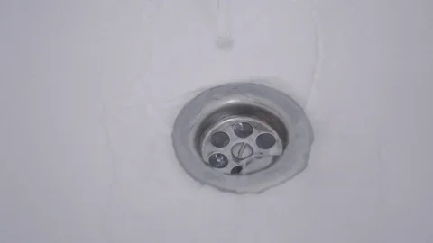 Close up of streaming water in sink going down through drain Stock Footage 118595956