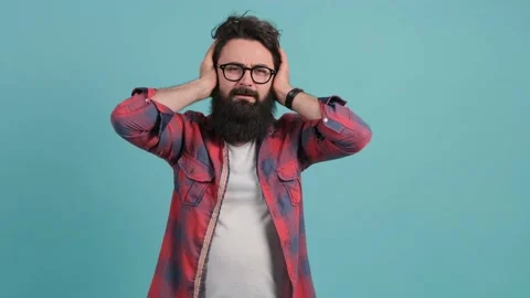 Close up of a stressed man covering ears with hands, shouting. Stock Footage 141366536