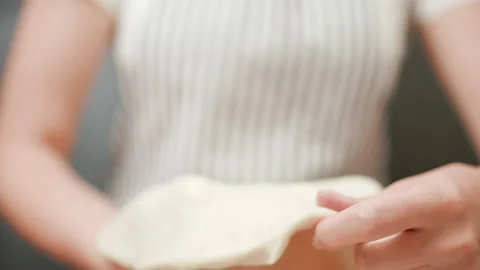 Close-up of stretching a pizza dough in slow-motion in 4K. Stock Footage 137429786