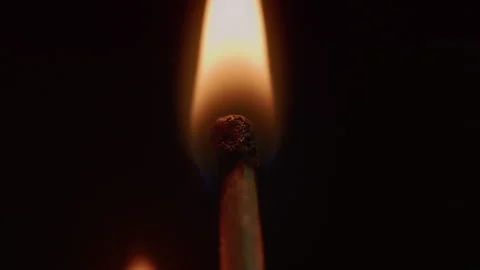 Close-up of striking and lighting a match in dark. Dramatic ignition of a Stock Footage 334842212