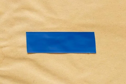 Close-up of a strip of blue electrical tape applied to textured brown paper Stock Photos