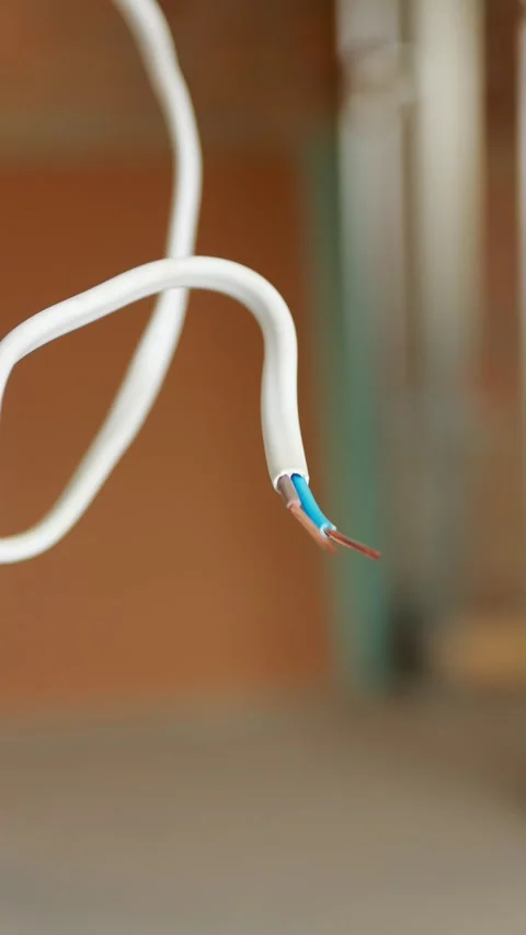 Close-up of a stripped electrical cable with exposed wires hanging from a w.. Stock Footage 345128335