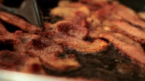 Close up strips of bacon frying in a pan. Frying bacon slices on the pan. 스톡 동영상 334641773