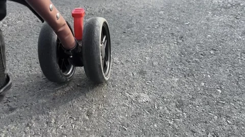 Close Up Stroller Wheels On Rough Asphalt Road Stockbeeldmateriaal 337415123