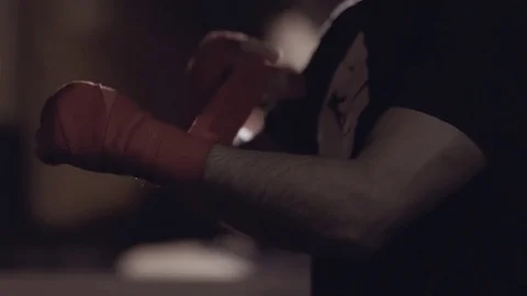Close-up of strong arms of a man putting on wrist wraps to prepare to train. Stock-Footage 76912525