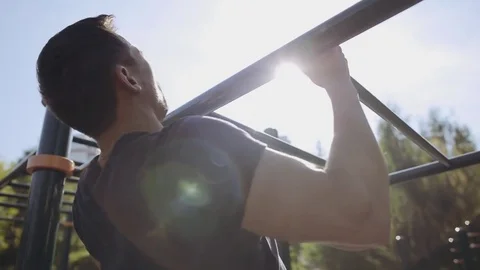 Close up of strong athlete doing pull-up on horizontal bar outdoors Stock Footage 83676231