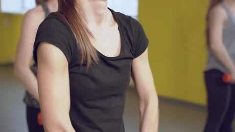 Close up of strong female hands doing exercises with dumbbells in the gym Stock Footage 131327404