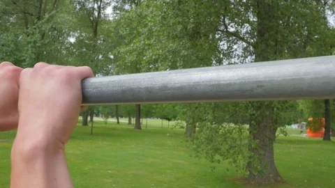 Close up of strong man doing pull-up on horizontal bar outdoors Video stock 84003220
