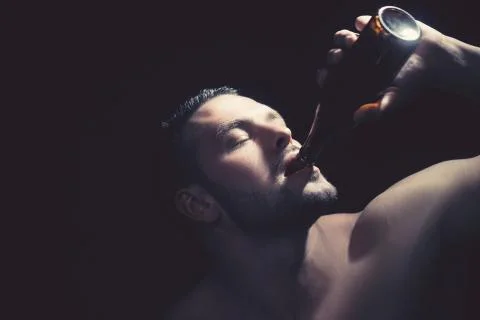 Close up of a strong man drinking a bottle of beer. Stock-Fotos