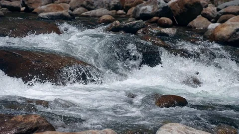 Close-up of the strong valley water flows among the rocks Stock Footage 133714284