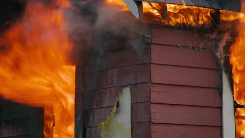 Close Up of a Structure Fire as the flames spread out and firemen assess. Stock Footage 201907675