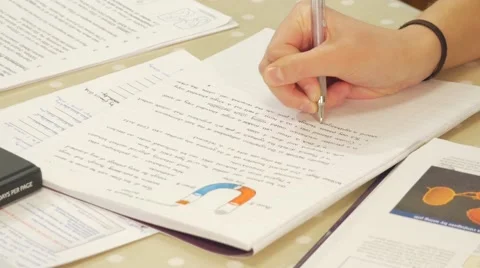 Close up of student doing homework from across the table Stock Footage 47014801