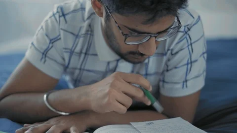 Close-Up,Student in Glasses Thoughtfully Reads Entries in the Lay Lie on the Bed Stock Footage 108103754