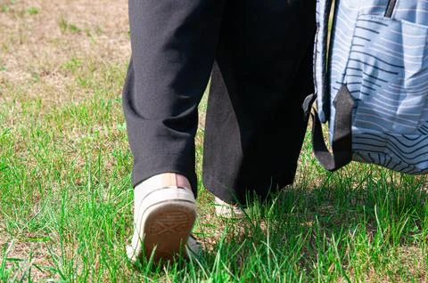 Close-up student going on grass with her backpack Foto stock
