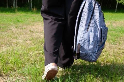 Close-up student going on grass with her backpack Stock Photos