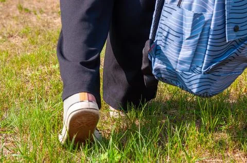 Close-up student going on grass with her backpack Stock Photos