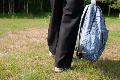 Close-up student going on grass with her backpack Stock Photos