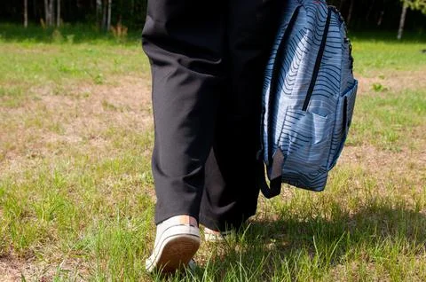Close-up student going on grass with her backpack Stock Photos