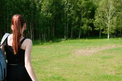 Close-up student going with her backpack, forest on background Stock Photos