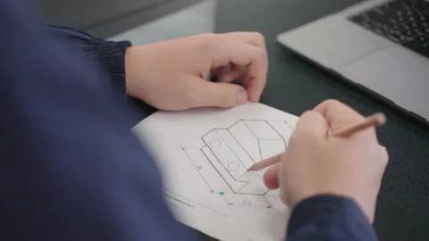 Close Up Of Student Hand Sketching 3D Model Design On Paper With Pencil, 4K Stock Footage 213565365