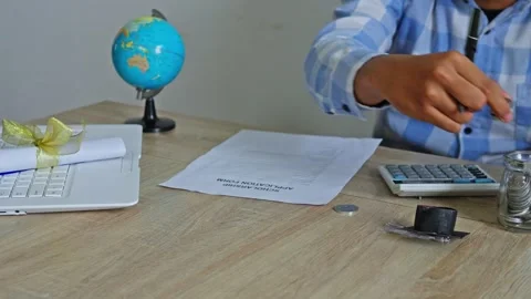 Close-up of student hands fill form and save coins into jar Stock Footage 333933328