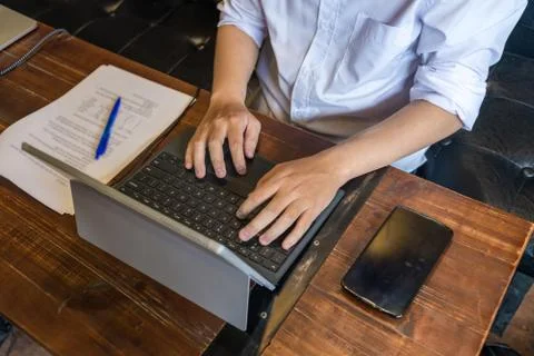 Close up of student hands using laptop on wood table Stock Photos