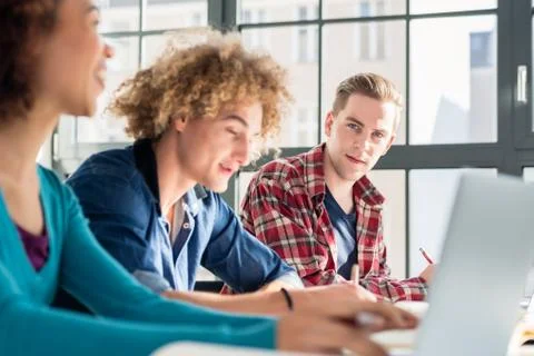 Close-up on student holding a pen over a book while studying a t Stock Photos