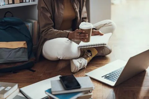 Close up of student sitting with notes coffee and modern laptop Stock Photos