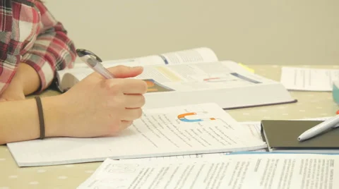 A close up of a student writing down notes for her biology essay Stock Footage 47015387
