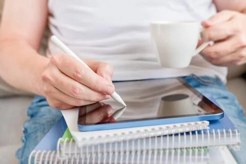Close-up of student writing notes in digital tablet screen  while sitting on  Stock Photos