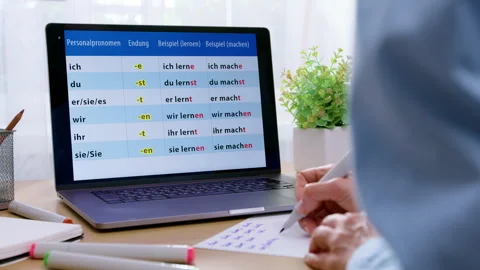 Close-up of a student writing notes while studying German grammar words  Stock Footage 342229436