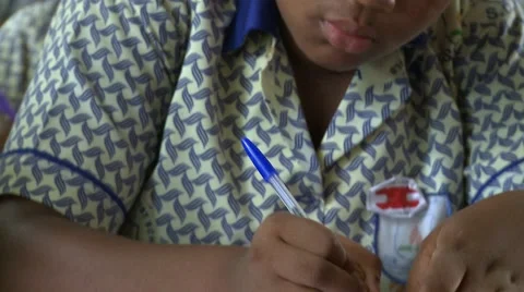 CLOSE UP: STUDENT WRITING - TILT UP FROM PAPER TO STUDENT Stock Footage 60115960