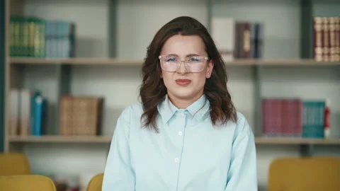 Close up of student yelling in anger at library with glasses and bookshelf Stock Footage 343556425