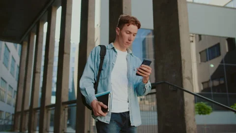 Close up student young handsome man with red hair walking down the stairs near Stock Footage 142049549