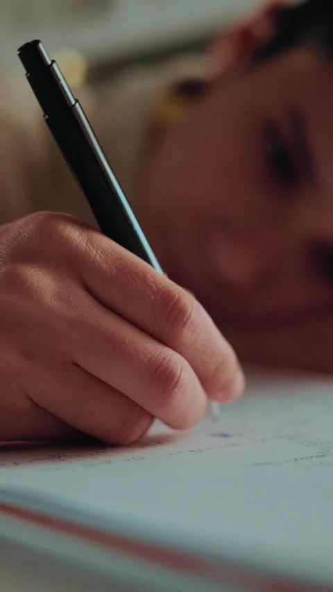 Close-up of a Student's Hand Writing Homework in a Notebook Stock Footage 336388725
